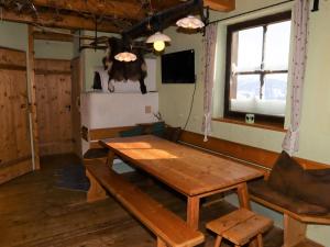 Pokój z drewnianym stołem i krową na ścianie w obiekcie Mountain hut right in the Kitzbühel ski area w mieście Mittersill