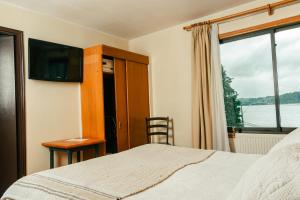1 dormitorio con cama y ventana en Hotel Terrazas del Lago en Puerto Varas