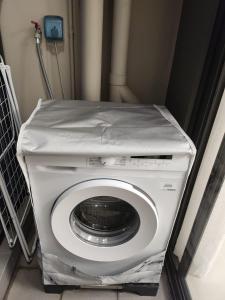 uma máquina de lavar roupa com um lençol em cima em Rimini house Homestay at Vinhome Ocean Park em Gia Lâm Pho