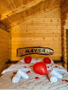 a bed in a wooden room with tomatoes on it at Maysa Suit Bungalov in Çamlıhemşin