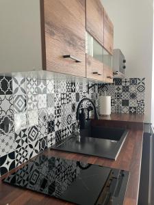 a kitchen with a sink and a tiled wall at Noclegi u Anny in Rzemień +7 photos