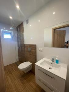a white bathroom with a toilet and a sink at Noclegi u Anny in Rzemień