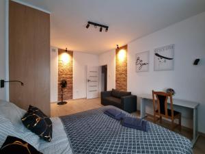 - une chambre avec un lit, un bureau et un canapé dans l'établissement Apartament 51, à Gdynia