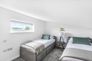 two beds in a white room with a window at Lakeside Lodge by Grandeur Property in Sturminster Marshall