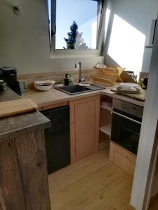 a kitchen with a sink and a stove and a window at Studio Pour 4 Personnes in Chamrousse