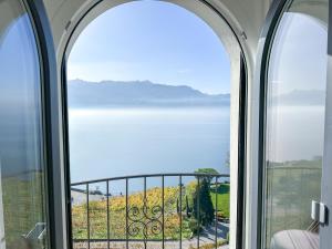 una finestra ad arco con vista sull'oceano di Room with 360° view overlooking Lake Geneva and Alps a Puidoux