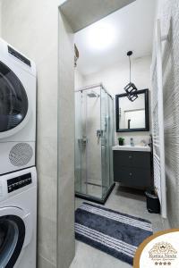 a bathroom with a shower and a washing machine at Rustica Nocte Boutique Apartments in Požega