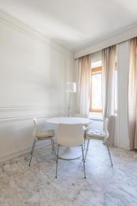 a white dining room with a table and chairs at White Suite in Rome in Rome