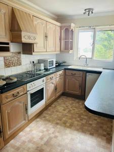 a kitchen with wooden cabinets and a counter top at One Bedroom Apartment with Balcony at Colliford Tavern & Holiday Site in Bodmin