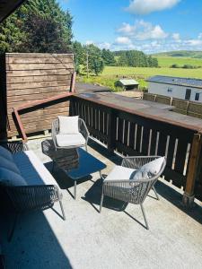 a patio with chairs and a bench on a deck at One Bedroom Apartment with Balcony at Colliford Tavern & Holiday Site in Bodmin