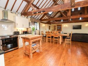 a kitchen and dining room with wooden floors and a table at The Old Carthouse in Nantwich