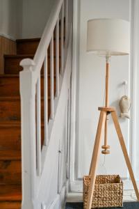 a floor lamp in a hallway with a staircase at LA DAME - ETRETAT in Étretat