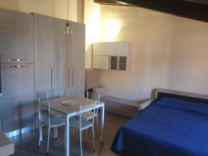 una camera con letto, tavolo e sedie di Monolocale Seveso - Affitti brevi - Residence a Seveso