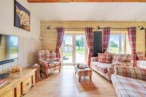 a living room with a couch and two chairs at The Cow Shed in Sherborne