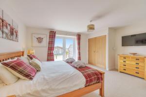 a bedroom with a large bed and a window at The Cow Shed in Sherborne