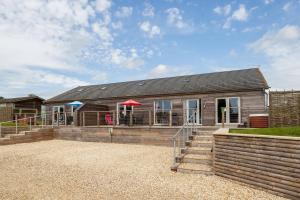 uma casa com um guarda-chuva vermelho em frente em The Cow Shed em Sherborne