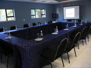 a long table in a room with blue tables and chairs at Masili Boutique Hotel in Louis Trichardt