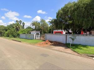 an empty road with a fence and a house at Masili Boutique Hotel in Louis Trichardt