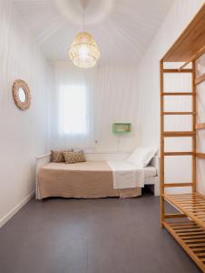 a white bedroom with a bed and a ladder at Casa al Mare 10 in Fano