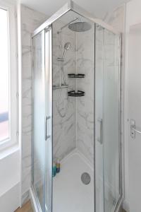 a shower with a glass enclosure in a bathroom at LA DAME - ETRETAT in Étretat