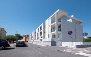 un grand bâtiment blanc sur le côté d'une rue dans l'établissement Casa al Mare 10, à Fano