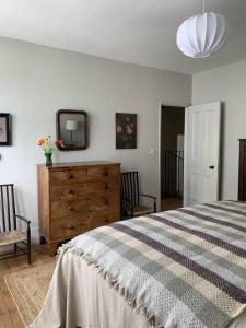1 dormitorio con cama, tocador y espejo en Ollerton, en Kent