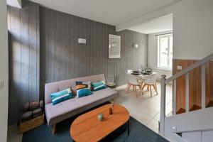 a living room with a couch and a table at LA DAME Avec TERRASSE- ETRETAT in Étretat