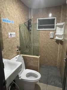 a bathroom with a toilet and a shower and a sink at พบรักรีสอร์ท Pobruk resort in Tha Bo