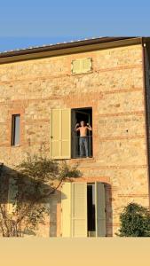un hombre tomando una foto de sí mismo desde una ventana en Villa Fontelinda, en Scansano