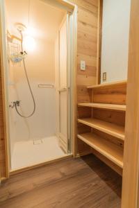 a bathroom with a shower and a walk in closet at 交流宿　星降る家　いこい in Gujo