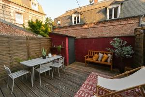 a patio with a table and chairs on a wooden deck at LA DAME Avec TERRASSE- ETRETAT in Étretat