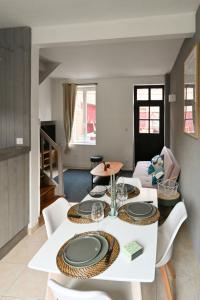 a dining room with a white table and chairs at LA DAME - ETRETAT in Étretat