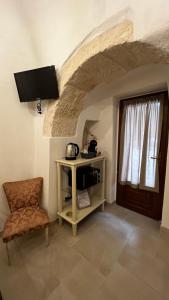 Cette chambre dispose d'une télévision, d'une chaise et d'une porte. dans l'établissement Locazione turistica il boschetto, à Martina Franca