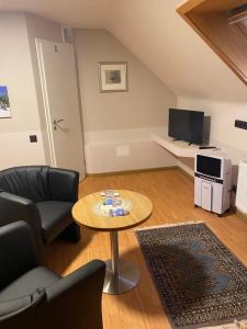 uma sala de estar com uma mesa e uma televisão em Pension MonaLisa em Bernkastel-Kues