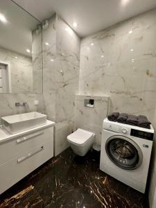 y baño con lavadora y lavamanos. en SDH 4 Radzymin comfortable apartment near Warsaw, en Radzymin