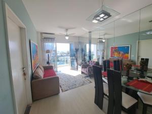 Una sala de estar con un sofá y un comedor. en Quarto privativo em Apto Barra com Vista - com anfitrião, en Río de Janeiro