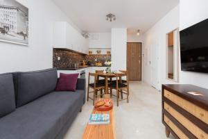a living room with a couch and a table at Plac Unii Apartment Gdynia City Centre by Noclegi Renters in Gdynia
