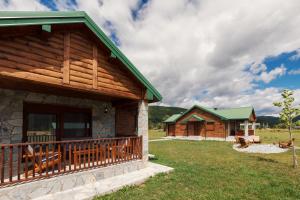 une cabane en rondins avec une terrasse couverte et un bâtiment dans l'établissement Eco Village & Chalets Green Heaven, à Mojkovac