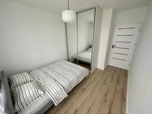 1 dormitorio con cama y espejo grande en SDH 4 Radzymin comfortable apartment near Warsaw, en Radzymin