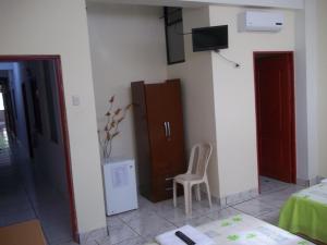 Habitación con cama, silla y TV. en Casa Linda II, en Iquitos