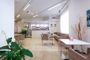 a restaurant with tables and chairs in a room at Ambra Hotel Cattolica in Cattolica