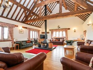 a large living room with leather furniture and wooden ceilings at Cromwells Manor in Nantwich