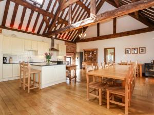 an open kitchen and dining room with a wooden table and chairs at Cromwells Manor in Nantwich