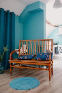 a wooden bench in a room with blue walls at Logis Le P'tit Rouillon au Rythme de la Meuse in Annevoie-Rouillon