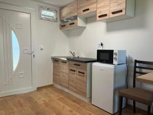 cocina con nevera blanca y microondas en Szegedi Partfürdő Kemping és Apartman, en Szeged