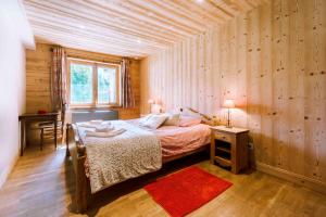 ein Schlafzimmer mit einem Bett in einem Zimmer mit Holzwänden in der Unterkunft Appartement dans Chalet 4 étoiles in Valloire