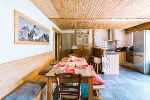 eine Küche mit einem langen Holztisch in einem Zimmer in der Unterkunft Appartement dans Chalet 4 étoiles in Valloire