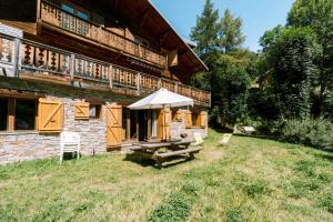 a picnic table with an umbrella outside of a building at Appartement dans Chalet 4 étoiles in Valloire