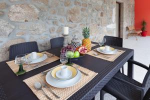 a black table with a table set with fruit on it at Casa da Tomada - Minho's Guest in Braga