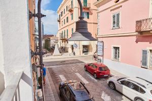 a view from a window of two cars parked on a street at House Giuà La Punzesa in Santa Teresa Gallura